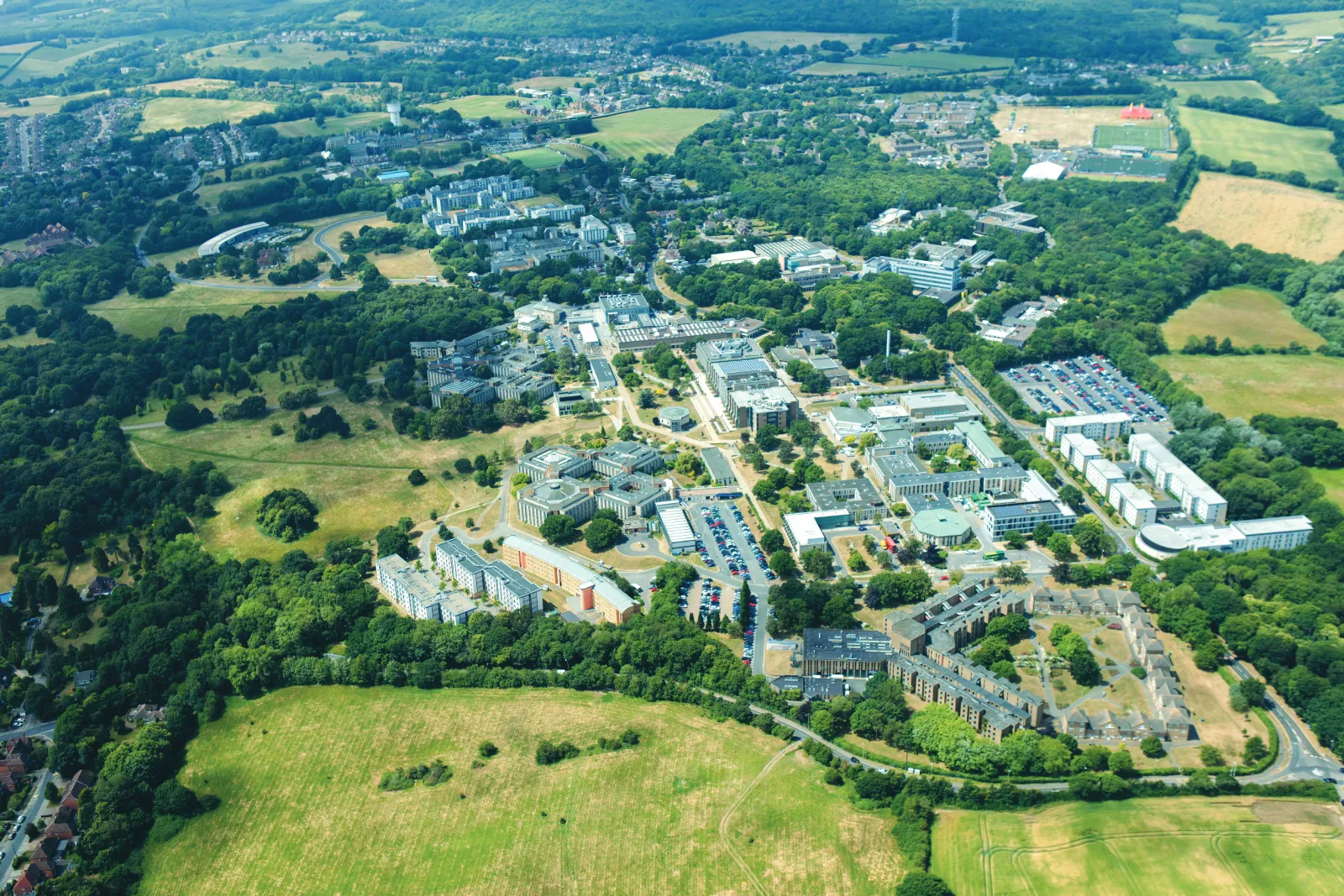 Aerial view of the leafy Kent campus, stretching out over fields